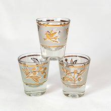 Load image into Gallery viewer, Vintage mid-century shot glasses featuring gold birds and botanicals on a frosted band with gold bands! Perfect to dress up a bar cart, bottoms up!
All pieces are in good vintage condition, no chips or cracks.
Each glass measures 1 5/8 x 2 1/2 inches
Capacity 1 ounce