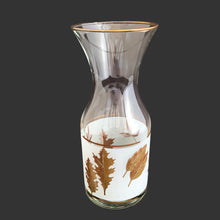 Load image into Gallery viewer, Vintage mid-century era Golden Foliage glass half carafe, decorated with a band of white with gold leaves and gold trim. Crafted by Libbey Glass, USA, 1953 - 1978. Add some Hollywood glam to your barware collection!
In excellent condition, no chips.
Measures 3 1/8 x 7 1/2 inches
Capacity 16 ounces