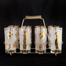 Load image into Gallery viewer, Set of eight mid-century vintage Golden Foliage highball glasses in brass carrying caddy with spiral handle. Produced by the Libbey Glass Company between 1953 - 1978. These glasses will elevate any bar cart and are perfect for any occasion or cocktail! Great vintage condition. The glasses are free from chips/cracks. Minor wear present to the gold on the rim. Each glass measures 2-3/4" x 5-1/2" (12oz)