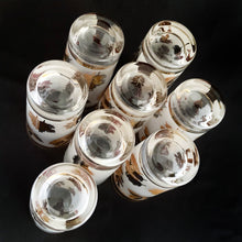 Load image into Gallery viewer, Set of eight mid-century vintage Golden Foliage highball glasses in brass carrying caddy with spiral handle. Produced by the Libbey Glass Company between 1953 - 1978. These glasses will elevate any bar cart and are perfect for any occasion or cocktail! Great vintage condition. The glasses are free from chips/cracks. Minor wear present to the gold on the rim. Each glass measures 2-3/4" x 5-1/2" (12oz)