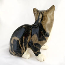 Load image into Gallery viewer, Highly desirable and collectible, this sweet vintage ceramic seated grey/brown striped tabby cat figurine has striking amber cathedral glass eyes (if you look at the eyes and move, the eyes will follow you). Produced by artist Mike Hinton, England (retired from Winstanley). In excellent condition, free from chips/cracks. Signed by the artist and marked with the # 33 and England. Dimensions: 5-1/4" x 3-3/4" x 5-3/4"