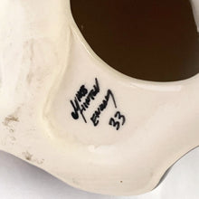 Load image into Gallery viewer, Highly desirable and collectible, this sweet vintage ceramic seated grey/brown striped tabby cat figurine has striking amber cathedral glass eyes (if you look at the eyes and move, the eyes will follow you). Produced by artist Mike Hinton, England (retired from Winstanley). In excellent condition, free from chips/cracks. Signed by the artist and marked with the # 33 and England. Dimensions: 5-1/4" x 3-3/4" x 5-3/4"