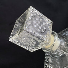 Load image into Gallery viewer, Vintage clear glass liquor decanter with an overall hobnail pattern and circular medallion on each side, topped with a square hobnail stopper. A fabulous addition to your bar cart for your favourite liquor, or as a fruit juice decanter on your brunch buffet.
Excellent condition, no chips. Stopper has a plastic insert for a tight seal.
Measures 3 5/8 x 3 5/8 x 9 1/2 inches