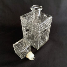 Load image into Gallery viewer, Vintage clear glass liquor decanter with an overall hobnail pattern and circular medallion on each side, topped with a square hobnail stopper. A fabulous addition to your bar cart for your favourite liquor, or as a fruit juice decanter on your brunch buffet.
Excellent condition, no chips. Stopper has a plastic insert for a tight seal.
Measures 3 5/8 x 3 5/8 x 9 1/2 inches