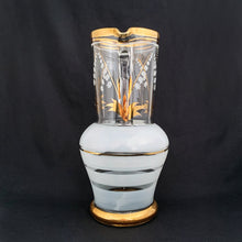 Load image into Gallery viewer, Vintage blown glass pitcher beautifully detailed with white Lily-of-the-Valley with gold leaves along with soft white and gold bands and applied blown glass handle. The perfect piece of serveware for spring and summer gatherings! Crafted in the Czech Republic, 1950s.
In excellent condition, no chips.
Measures 5 x 11 1/8 inches