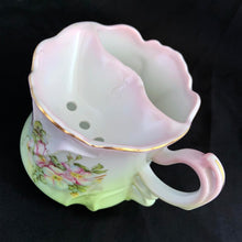 Load image into Gallery viewer, This vintage white porcelain shaving mug is hand painted with lovely pink and green florals with gold rim. Use as intended or repurpose as a toothbrush or make-up brush holder. Marked "Hand Painted Nippon". In excellent condition, no chips/cracks/repairs. Dimensions: 4-3/4" x 3-3/4"