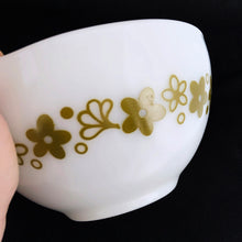 Load image into Gallery viewer, Fabulous find in this vintage PYREX "Spring Blossoms Green I" or commonly known as "Crazy Daisy" white milk glass Cinderella bowl with green daisy flowers on this 441, 1-1/2 pint beauty! Produced by Corning USA, first between 1972 to 1979 and again between 1979 to 1981. In excellent condition, no chips or cracks. Looks like it hasn't seen a dishwasher and the pattern in shiny and vibrant. Measures 7-1/2" x 3-1/8" (handle-handle)