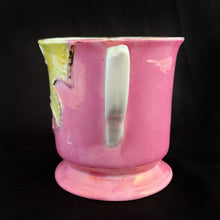 Load image into Gallery viewer, Vintage wood handled shaving brush and white porcelain shaving mug with raised slip details painted in pink, yellow and blue, highlighted in gold. Use as intended or repurpose as a toothbrush or make-up brush holder. Impressed mark "510" and painted "13". In good vintage condition, no cracks/repairs. The edge on the soap side is worn. Dimensions: 3-1/8" x 3"