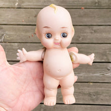 Load image into Gallery viewer, Rare porcelain bisque Kewpie Doll figurine with moveable string jointed arms. It's difficult to find this specific one standing with its legs apart which is what makes this one rare. Excellent vintage condition, free from chips or cracks. String could be tightened. This delightful little cutie stands at approximately 7" inches tall and comes with a metal stand.