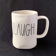 Load image into Gallery viewer, "LAUGH" off white ceramic mug. Marked on the bottom, Rae Dunn Artisan Collection by Magenta 202. Rae Dunn's designs are instantly recognizable....they are mostly cream-colored tableware, typically emblazoned with one- or two-word phrases using a simple hand-written style font. In excellent condition free from chips/cracks/repairs. Measures 5 x 4 1/2 inches (includes handle) Capacity 16 ounces
