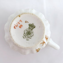 Load image into Gallery viewer, Antique Victorian style "Rutland" demitasse cup and saucer, with blue and yellow flowers trimmed in gold gilt. Crafted by Doulton Burslem, Staffordshire England, circa 1891 - 1902. An absolutely stunning addition to your teacup collection! In excellent condition, free from chips/cracks/repairs. Makers marks present. Cup measures 2 1/8 x 2 1/8 inches and saucer is approximately 4 inches