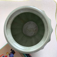 Load image into Gallery viewer, The sage green colour with tiny brown flecks is perfection on this round Grecian style urn round planter. Produced by Haeger U.S.A. for FTD, circa 1970. Fill this beauty with houseplants, succulents or a beautiful bouquet of flowers. Whatever you choose it'll make a fabulous addition to your décor. In excellent condition, no chips or cracks. Stamped on the bottom with DESIGNED EXCLUSIVELY FOR FLORISTS TELEGRAPH DELIVERY ASSOCIATION, HAEGER USA. Measures 6 1/4 x 6 1/2 inches