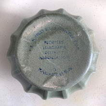 Load image into Gallery viewer, The sage green colour with tiny brown flecks is perfection on this round Grecian style urn round planter. Produced by Haeger U.S.A. for FTD, circa 1970. Fill this beauty with houseplants, succulents or a beautiful bouquet of flowers. Whatever you choose it'll make a fabulous addition to your décor. In excellent condition, no chips or cracks. Stamped on the bottom with DESIGNED EXCLUSIVELY FOR FLORISTS TELEGRAPH DELIVERY ASSOCIATION, HAEGER USA. Measures 6 1/4 x 6 1/2 inches
