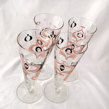 Load image into Gallery viewer, Make any day a special occasion with these highly collectible and hard to find vintage mid-century atomic style Seville pilsner or champagne glasses. Decorated with a graphic geometric design in swirls of pink, charcoal black and gold, they remind us of a New Year's eve party and are perfect for that midnight champagne toast! Bonus, they come in the original wood handled brass caddy.