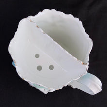 Load image into Gallery viewer, This vintage white porcelain shaving mug begs the question, "who is the fairest of them all" with it's unique round mirror edged in enamel or copper. The mug is hand painted with lovely pink and yellow roses and decorative edge with gold. Use as intended or repurpose as a toothbrush or make-up brush holder. Stamped with maker's mark, "Royal Coburg, Germany". In used vintage condition, minor chips at the edge no cracks/repairs. Measures 3 1/8 x 3 inches