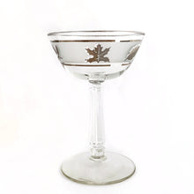 Load image into Gallery viewer, Vintage mid-century Silver Leaf champagne coupe or martini glass featuring silver leaves set on a frosted band, silver bands, grecian column stem. Crafted by Libbey Glass, USA, 1953 - 1978. These put the "glam" in glamourous — a stunning addition to your barware collection and perfect for ringing in the New Year with a toast! Also makes a wonderful wedding or housewarming gift for any cocktail enthusiast.
In excellent condition, no chips. Minimal wear.
Measures 3 3/4 x 5 5/8 inches
Capacity 7 ounces
