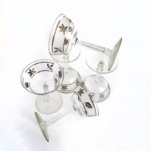 Load image into Gallery viewer, Vintage mid-century Silver Leaf champagne coupe or martini glass featuring silver leaves set on a frosted band, silver bands, grecian column stem. Crafted by Libbey Glass, USA, 1953 - 1978. These put the "glam" in glamourous — a stunning addition to your barware collection and perfect for ringing in the New Year with a toast! Also makes a wonderful wedding or housewarming gift for any cocktail enthusiast.
In excellent condition, no chips. Minimal wear.
Measures 3 3/4 x 5 5/8 inches
Capacity 7 ounces