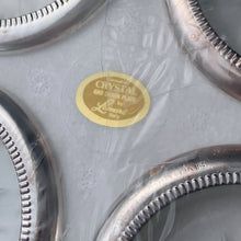 Load image into Gallery viewer, Vintage set of 4 silver plate rimmed crystal coasters featuring a cut sunburst and finished in a silver plate rolled rim with beaded detail. Perfect to protect your furniture from water marks. A super sparkly and elegant resting place for your beverage!
In excellent condition. In original box. Crafted by Leonard in Italy.
Each coaster measures 4 x 3/4 inches