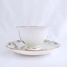 Load image into Gallery viewer, This antique bone china footed teacup and saucer is so sweet! Both the cup and saucer have a lovely scalloped edge with hand painted whimsical pastel coloured foxglove flowers and rimmed with gold gilt. Produced by Royal Albert, England, circa 1917 - 1927. In good condition. Teacup measures 3 3/4 x 2 3/8 inches | Saucer measures 5 1/2 inches