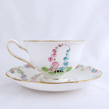 Load image into Gallery viewer, This antique bone china footed teacup and saucer is so sweet! Both the cup and saucer have a lovely scalloped edge with hand painted whimsical pastel coloured foxglove flowers and rimmed with gold gilt. Produced by Royal Albert, England, circa 1917 - 1927. In good condition. Teacup measures 3 3/4 x 2 3/8 inches | Saucer measures 5 1/2 inches