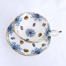 Load image into Gallery viewer, Antique bone china teacup and saucer with scalloped edge and decorated with hand painted pansies and roses with a blue graphic plant and rimmed with gold gilt. Produced by Coalport, England, circa 1900. In good condition, free from chips, cracks and repairs. Manufacturer's defect to the right of the handle at the rim. Pattern number 8252 and maker's marks are on the bottom of the teacup and maker's mark on the saucer. Teacup measures 4" x 2-1/8" | Saucer measures 5-3/4"