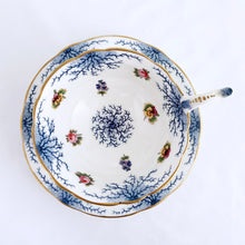 Load image into Gallery viewer, Antique bone china teacup and saucer with scalloped edge and decorated with hand painted pansies and roses with a blue graphic plant and rimmed with gold gilt. Produced by Coalport, England, circa 1900. In good condition, free from chips, cracks and repairs. Manufacturer's defect to the right of the handle at the rim. Pattern number 8252 and maker's marks are on the bottom of the teacup and maker's mark on the saucer. Teacup measures 4" x 2-1/8" | Saucer measures 5-3/4"