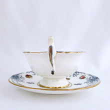 Load image into Gallery viewer, Antique bone china teacup and saucer with scalloped edge and decorated with hand painted pansies and roses with a blue graphic plant and rimmed with gold gilt. Produced by Coalport, England, circa 1900. In good condition, free from chips, cracks and repairs. Manufacturer's defect to the right of the handle at the rim. Pattern number 8252 and maker's marks are on the bottom of the teacup and maker's mark on the saucer. Teacup measures 4" x 2-1/8" | Saucer measures 5-3/4"