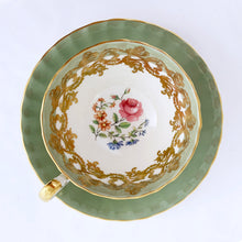 Load image into Gallery viewer, vintage bone china teacup and saucer with a lovely scalloped shape. The cup is a lovely shade of celadon green, interior celadon band is overlaid with a complex gold pattern with a central bouquet of colourful flowers. Saucer is celadon green with a white centre and gold gilt rim. Produced by Aynsley, England, circa 1939. In excellent condition, free from chips, cracks and repairs. Pattern number C1557 with maker's marks. Teacup measures 3-1/2" x 2-1/4" | Saucer measures 5-5/8"