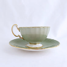 Load image into Gallery viewer, vintage bone china teacup and saucer with a lovely scalloped shape. The cup is a lovely shade of celadon green, interior celadon band is overlaid with a complex gold pattern with a central bouquet of colourful flowers. Saucer is celadon green with a white centre and gold gilt rim. Produced by Aynsley, England, circa 1939. In excellent condition, free from chips, cracks and repairs. Pattern number C1557 with maker's marks. Teacup measures 3-1/2" x 2-1/4" | Saucer measures 5-5/8"