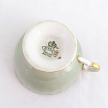 Load image into Gallery viewer, vintage bone china teacup and saucer with a lovely scalloped shape. The cup is a lovely shade of celadon green, interior celadon band is overlaid with a complex gold pattern with a central bouquet of colourful flowers. Saucer is celadon green with a white centre and gold gilt rim. Produced by Aynsley, England, circa 1939. In excellent condition, free from chips, cracks and repairs. Pattern number C1557 with maker's marks. Teacup measures 3-1/2" x 2-1/4" | Saucer measures 5-5/8"