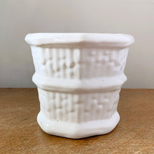 Load image into Gallery viewer, Vintage eight panel white ceramic planter with a basketweave pattern bordered with thick bands. Produced in Canada. In excellent condition, free from chips/cracks. Marked on the bottom, but we are unable to decipher except for the word "CANADA". Measures 5-1/8" x 4-1/4"