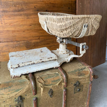 Load image into Gallery viewer, Vintage cast iron platform scale with wicker basket. Crafted by W.T. Avery Ltd., Birmingham, England, 1930s. The paint is chippy perfection and the basket is in great condition considering its age. This would have been used in a grocers, or as a baby scale. Would look amazing in any shabby chic or farmhouse decor filled with fruits, breads or a lovely dried floral arrangement. A one-of-a-kind display piece!
In as found vintage condition.
Measures 25 x 47 inches