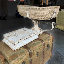 Load image into Gallery viewer, Vintage cast iron platform scale with wicker basket. Crafted by W.T. Avery Ltd., Birmingham, England, 1930s. The paint is chippy perfection and the basket is in great condition considering its age. This would have been used in a grocers, or as a baby scale. Would look amazing in any shabby chic or farmhouse decor filled with fruits, breads or a lovely dried floral arrangement. A one-of-a-kind display piece!
In as found vintage condition.
Measures 25 x 47 inches
