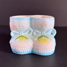 Load image into Gallery viewer, Vintage white baby booties planter with blue bows and edge details, plus a little green and yellow. This adorable planter would look lovely filled with your favourite plant or succulent or use it to store and display baby accessories. Sticker on the bottom 'Parma by AAI Taiwan'. Excellent condition, no chips or cracks. Size: 4" x 4" x 3"