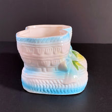 Load image into Gallery viewer, Vintage white baby booties planter with blue bows and edge details, plus a little green and yellow. This adorable planter would look lovely filled with your favourite plant or succulent or use it to store and display baby accessories. Sticker on the bottom 'Parma by AAI Taiwan'. Excellent condition, no chips or cracks. Size: 4" x 4" x 3"