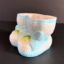 Load image into Gallery viewer, Vintage white baby booties planter with blue bows and edge details, plus a little green and yellow. This adorable planter would look lovely filled with your favourite plant or succulent or use it to store and display baby accessories. Sticker on the bottom 'Parma by AAI Taiwan'. Excellent condition, no chips or cracks. Size: 4" x 4" x 3"