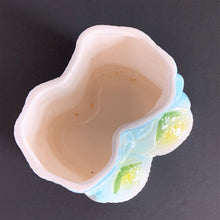 Load image into Gallery viewer, Vintage white baby booties planter with blue bows and edge details, plus a little green and yellow. This adorable planter would look lovely filled with your favourite plant or succulent or use it to store and display baby accessories. Sticker on the bottom 'Parma by AAI Taiwan'. Excellent condition, no chips or cracks. Size: 4" x 4" x 3"