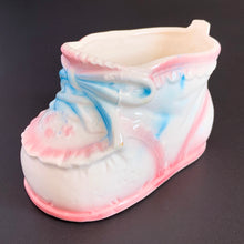 Load image into Gallery viewer, Vintage white ceramic baby bootie planter with blue bows and pink details. Crafted by Rubens Originals, Japan, 1950s. A perfect addition to nursery decor to hold a plant or baby accessories!
Excellent condition, no chips or cracks. Marked on the bottom.
Measures 4 x 2 1/4 x 2 1/2 inches