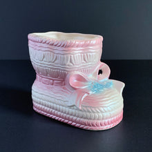 Load image into Gallery viewer, Vintage white lustreware ceramic baby bootie planter with pink bows and edge details, and a hint of blue. Crafted by Rubens Originals, Japan, 1950s. Adorable in a baby's nursery to house a small houseplant or use it to store accessories!
In excellent condition, no chips or cracks. Maker's mark.
Measures 4 x 4 x 3 inches