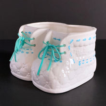 Load image into Gallery viewer, Vintage white booties ceramic planter with real blue laces and blue stitching detail. Crafted by China Ceramic Co., Taiwan, 1970s/80s. Perfect as nursery decor for a succulent or to store baby accessories.
In excellent condition, no chips or cracks.
Marked on the bottom with a 'CJ' in a circle and sticker.
Measures 6 1/2 x 4 1/2 x 3 1/2 inches