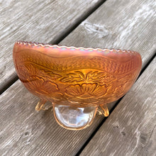Load image into Gallery viewer, This vintage Two Flowers marigold carnival glass bowl features an intricate design of dogwood flowers and marsh lilies, a smooth sawtooth rim and three spatulate feet. Crafted by Fenton Art Glass, early 20th century. The iridescence on this bowl is outstanding and it's sure to become a treasured heirloom. In excellent condition, no chips. Measures 6 1/4 x 3 1/2 inches