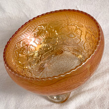 Load image into Gallery viewer, This vintage Two Flowers marigold carnival glass bowl features an intricate design of dogwood flowers and marsh lilies, a smooth sawtooth rim and three spatulate feet. Crafted by Fenton Art Glass, early 20th century. The iridescence on this bowl is outstanding and it's sure to become a treasured heirloom. In excellent condition, no chips. Measures 6 1/4 x 3 1/2 inches