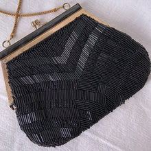 Load image into Gallery viewer, Stunning vintage art deco style beaded evening bag features black bugle and round glass beads in a fringe pattern, black silk lining, gold toned chain and kiss closure. Crafted by Artel, Hong Kong 1950s. Take your fashion to the next level with this elegant accessory.
In vintage condition, with a few beads missing.