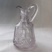 Load image into Gallery viewer, Antique EAPG glass cruet pitcher. Crafted by Flint Glass, USA, early 19th century. The glass has a violet tinge due to the manganese content in the glass which when exposed to sunlight has a tendency to turn violet in colour. A pretty piece!
In used vintage condition, flea bite on the inside rim where the stopper was placed.
Approximately 5 inches tall