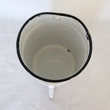 Load image into Gallery viewer, Vintage white and black rimmed enameled metal irrigator with spout. Crafted by Jones Metal Products Company, USA, 1950s. This handy vessel has a hole on the back for easy hanging which makes it perfect for storing kitchen utensils, paint brushes, garden tools or use as a garden planter.
In vintage condition. Original Jones Ware label.
Measures 5 1/4 x 7 1/4 inches