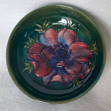 Load image into Gallery viewer, Vintage hand painted "Anemone" footed bowl on a deep green ground with shades of blue and red. In excellent condition, free from chips, cracks, repairs, crazing present. Paper label with Royal Warrant and "Potters to the late Queen Mary". Size: 4-1/2" x 1-1/2"