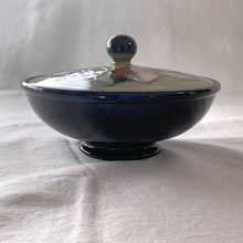 Load image into Gallery viewer, Vintage mid-century "Clematis" lidded dish with green ground lid and teal/blue ground on bowl's interior and deep blue on the exterior of the bowl. The colours are vibrant and the tube lining and hand painting are spectacular. Produced by Moorcroft Pottery, England, circa 1950s.  Measures 6-1/4" x 3-1/2"  Excellent condition. No cracks or chips. Normal crazing for a piece of this age. Impressed marks include Walter Moorcroft's signature, Potter to H.M. The Queen and Made in England.