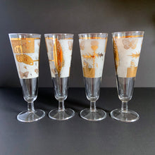 Load image into Gallery viewer, Set of four vintage mid-century Golden Meadow clear pilsner or champagne glasses featuring a delightful design of butterflies, thistles and botanicals in 22kt gold against a frosted band on Federal Glass blanks. Designed by Fred Press, USA, 1960s. These hard to find glasses will be a luxurious addition to any barware collection!
In excellent condition, no chips. Minor wear commensurate with age.
Measures 8 1/2 inches tall
Capacity 8 ounces