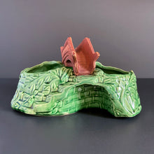 Load image into Gallery viewer, A vintage ceramic planter featuring a rusty red bridge over a green pond with impressed brick wall and stairs, and floral details. Crafted by Shawnee Pottery, USA, 1950s. Create a unique garden with this unique planter!
In vintage condition with minor flea bites to the bridge.
Measures 9 x 5 3/4 x 4 3/4 inches