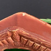 Load image into Gallery viewer, A vintage ceramic planter featuring a rusty red bridge over a green pond with impressed brick wall and stairs, and floral details. Crafted by Shawnee Pottery, USA, 1950s. Create a unique garden with this unique planter!
In vintage condition with minor flea bites to the bridge.
Measures 9 x 5 3/4 x 4 3/4 inches